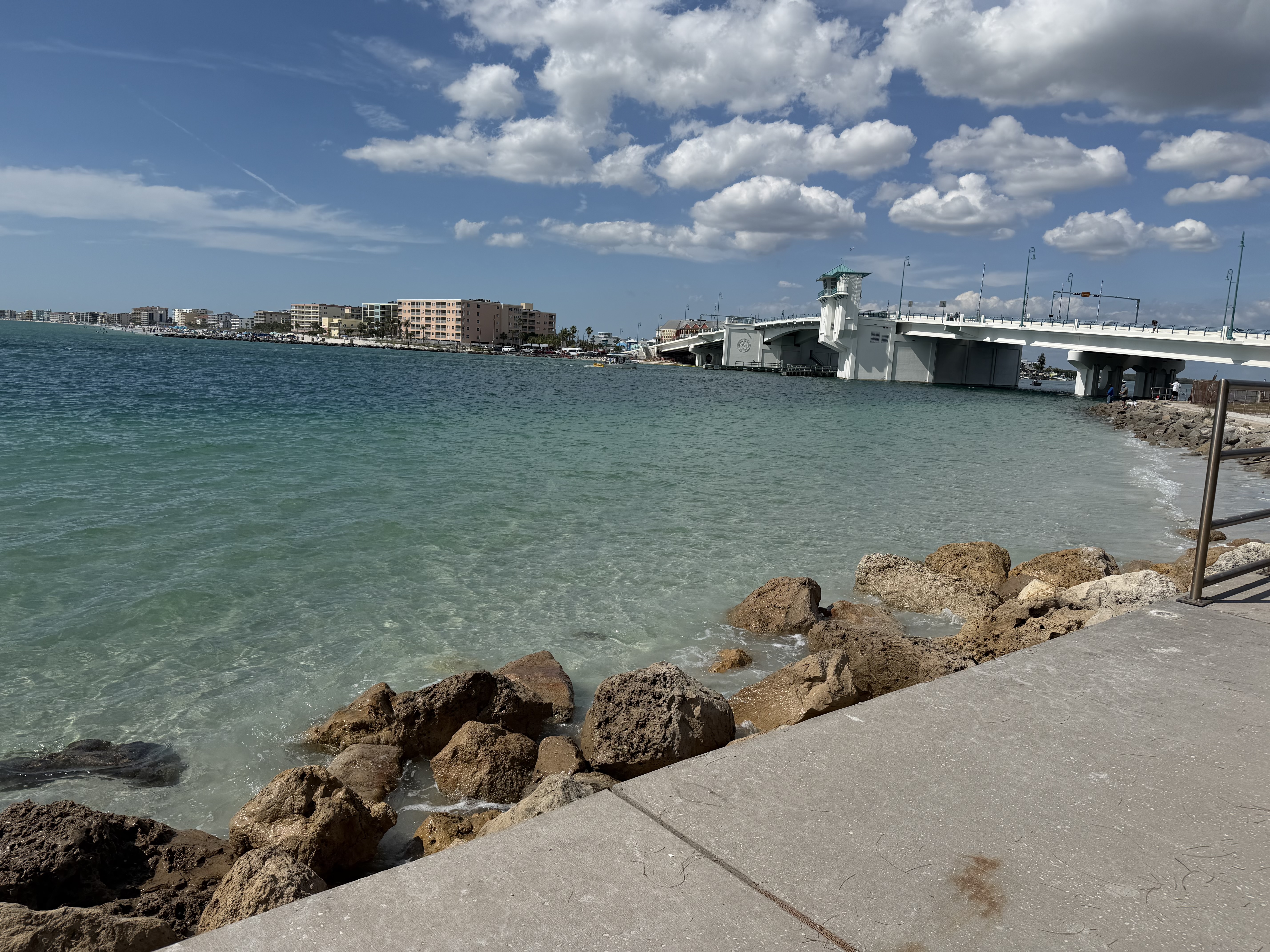 Tampa Bay waterfront with turquoise water, rocks, and bridge